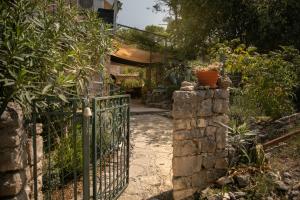 una puerta en un jardín con una pared de piedra en Apartman Silna your new home with terrace and garden, en Bobovišća