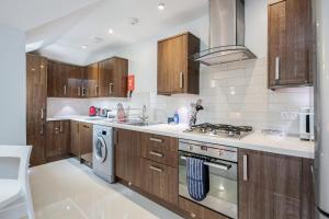 a kitchen with wooden cabinets and a stove top oven at Roomspace Serviced Apartments - Lomond Court in Surbiton