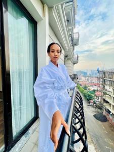 kobieta siedzi na balkonie budynku w obiekcie TH BonRoyal Hotel w Addis Abebie