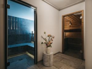 uma casa de banho com uma piscina de mergulho e um vaso com flores em VAYA Gerlos em Gerlos