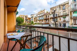 - un balcon avec une table, des chaises et des bâtiments dans l'établissement Lodging Apartments Liceu G1, à Barcelone