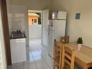 a kitchen with a table and a refrigerator and a table and a dining room at Residencial pimenta - aluguel temporada - apto mobiliado in Cuiabá