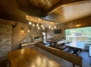 a room with tables and a fireplace in a cabin at Belvedere Hills in Dospat