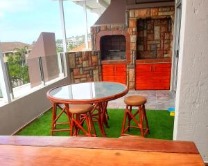 a glass table and two stools on a patio at Beach Splendor @ 24 La Crete Sands in Margate