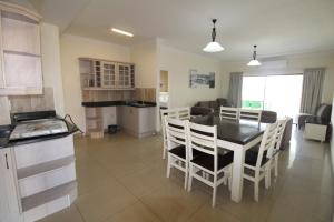 a kitchen and dining room with a table and chairs at Saints View Resort Unit 6 in Uvongo Beach