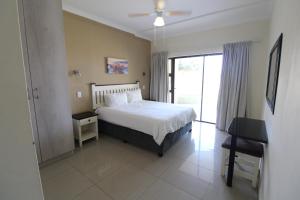 a bedroom with a bed and a sliding glass door at Saints View Resort Unit 6 in Uvongo Beach +21 photos