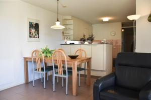 a kitchen and dining room with a wooden table and chairs at Libra 19 in Nes