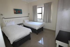 a hotel room with two beds and a window at Saints View Resort Unit 7 in Uvongo Beach +21 photos
