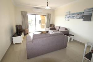 - un salon avec un canapé et une télévision dans l'établissement Saints View Resort Unit 7, à Uvongo Beach