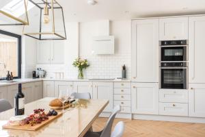 a kitchen with white cabinets and a table with fruit on it at Holly Hayes House in Instow