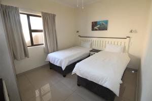 two beds in a room with a window at Saints View Resort Unit 9 in Uvongo Beach +18 photos