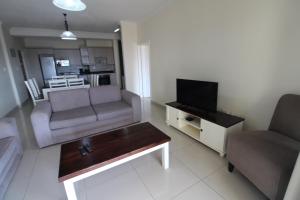 uma sala de estar com um sofá e uma televisão em Saints View Resort Unit 9 em Uvongo Beach