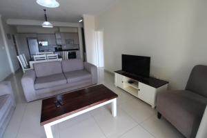 a living room with a couch and a television at Saints View Resort Unit 9 in Uvongo Beach