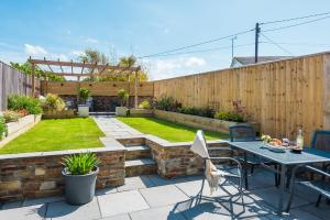 a patio with a table and chairs in a garden at Holly Hayes House in Instow