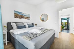 a bedroom with a large bed and a mirror at Hafenquartier No5 in Heiligenhafen