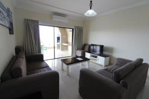 - un salon avec deux canapés et une télévision dans l'établissement Saints View Resort Unit 10, à Uvongo Beach
