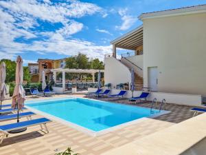 a swimming pool with blue chairs and a house at Affittacamere Bellavista Posada in Posada