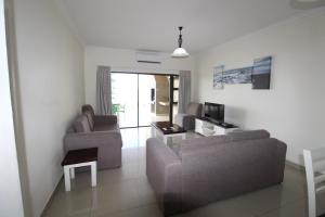 a living room with two couches and a tv at Saints View Resort Unit 13 in Uvongo Beach