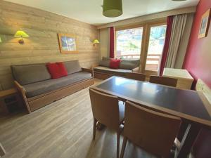 a living room with a couch and a table and chairs at Appartement skis aux pieds - 5 pers., balcon au sud - FR-1-513-78 in La Tania +1 photo