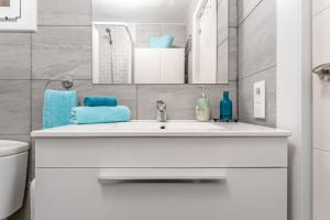 a bathroom with a white sink and blue towels at Beach Front Retro Hideaway in Salou in Salou +81 photos