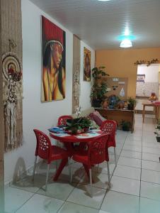 a dining room with a table and red chairs at Pousada La Duna Lençóis Maranhenses in Barreirinhas