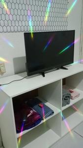 a flat screen tv sitting on top of a white shelf at Pousada La Duna Lençóis Maranhenses in Barreirinhas