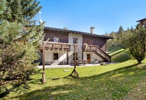 a stone house with a porch and a yard at Chalet Sonne Superior2 4 in Livigno
