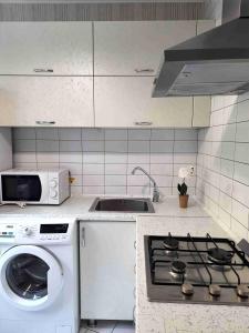 uma cozinha com um fogão e uma máquina de lavar roupa em Апартаменты Амстердам проспект Богдана Хмельницкого em Dnipro