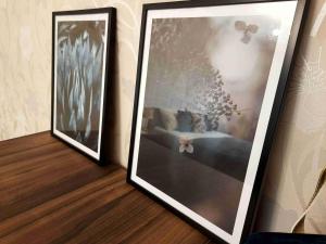 dwa oprawione zdjęcia siedzą na ścianie w obiekcie Апартаменты Амстердам проспект Богдана Хмельницкого w mieście Dniepr