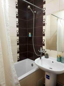 La salle de bains est pourvue d'un lavabo et d'une baignoire. dans l'établissement Апартаменты Амстердам проспект Богдана Хмельницкого, à Dnipro
