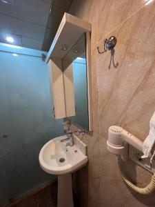 a bathroom with a sink and a mirror at Gabala Tufandag City Hotel in Gabala