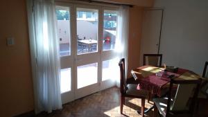 a dining room with a table and a large sliding glass door at Terraza La Falda in La Falda