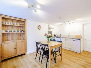 a kitchen with a table and chairs in a room at Branthwaite Cottage in Caldbeck