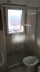 ein Bad mit einer Dusche, einem WC und einem Fenster in der Unterkunft Terraza La Falda in La Falda