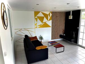 sala de estar con sofá y mesa en Plumeria Hébergement Tiare en Grand-Bourg