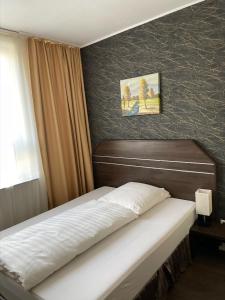 ハンブルクにあるHotel Grevenのベッドルーム1室(ベッド1台付)が備わります。壁には絵画が飾られています。