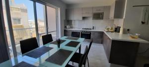 a kitchen with a table and chairs and a kitchen with a window at Lovely 3-bedroom apartment in Marsalforn, Gozo! in Marsalforn