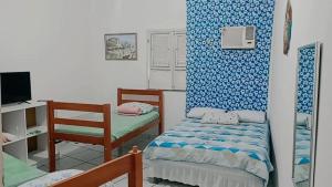 a small room with two beds and a tv at Pousada La Duna Lençóis Maranhenses in Barreirinhas