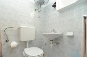 a bathroom with a toilet and a sink at Rooms Veli Vrh 2208 in Pula