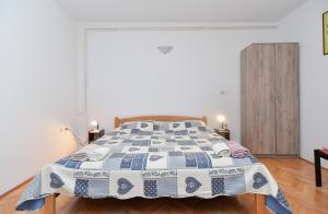 a bedroom with a bed with a blue and white quilt at Rooms Veli Vrh 2208 in Pula