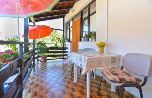 a table and chairs on a balcony with an umbrella at Rooms Veli Vrh 2208 in Pula