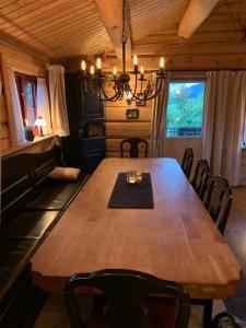 a dining room table with chairs and a chandelier at Havretunet på Havrefjell-cozy cabin with jacuzzi in Åmli