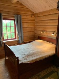 a bedroom with a bed in a log cabin at Havretunet på Havrefjell-cozy cabin with jacuzzi in Åmli