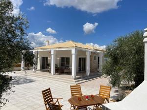 a house with a patio with chairs and a table at Villa Niva in Ayios Kirikos