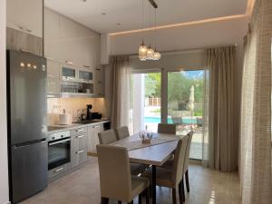 a kitchen with a table with chairs and a dining room at Villa Niva in Ayios Kirikos