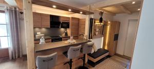 Hochalmbahnen Chalets Rauris 1-19, Maislaufeldweg 1s في راوريس: مطبخ مع كونتر وكراسي في غرفة