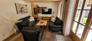 a living room with black leather chairs and a table at Hochalmbahnen Chalets Rauris 1-19, Maislaufeldweg 1s in Rauris