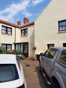 um carro branco estacionado em frente a uma casa em Mirandas Guest House em Berwick-Upon-Tweed