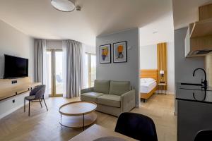 a living room with a couch and a room with a bed at Hotel Meridian in Chałupy