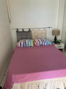 a large bed with a pink blanket and pillows at villa siber in Port-Louis